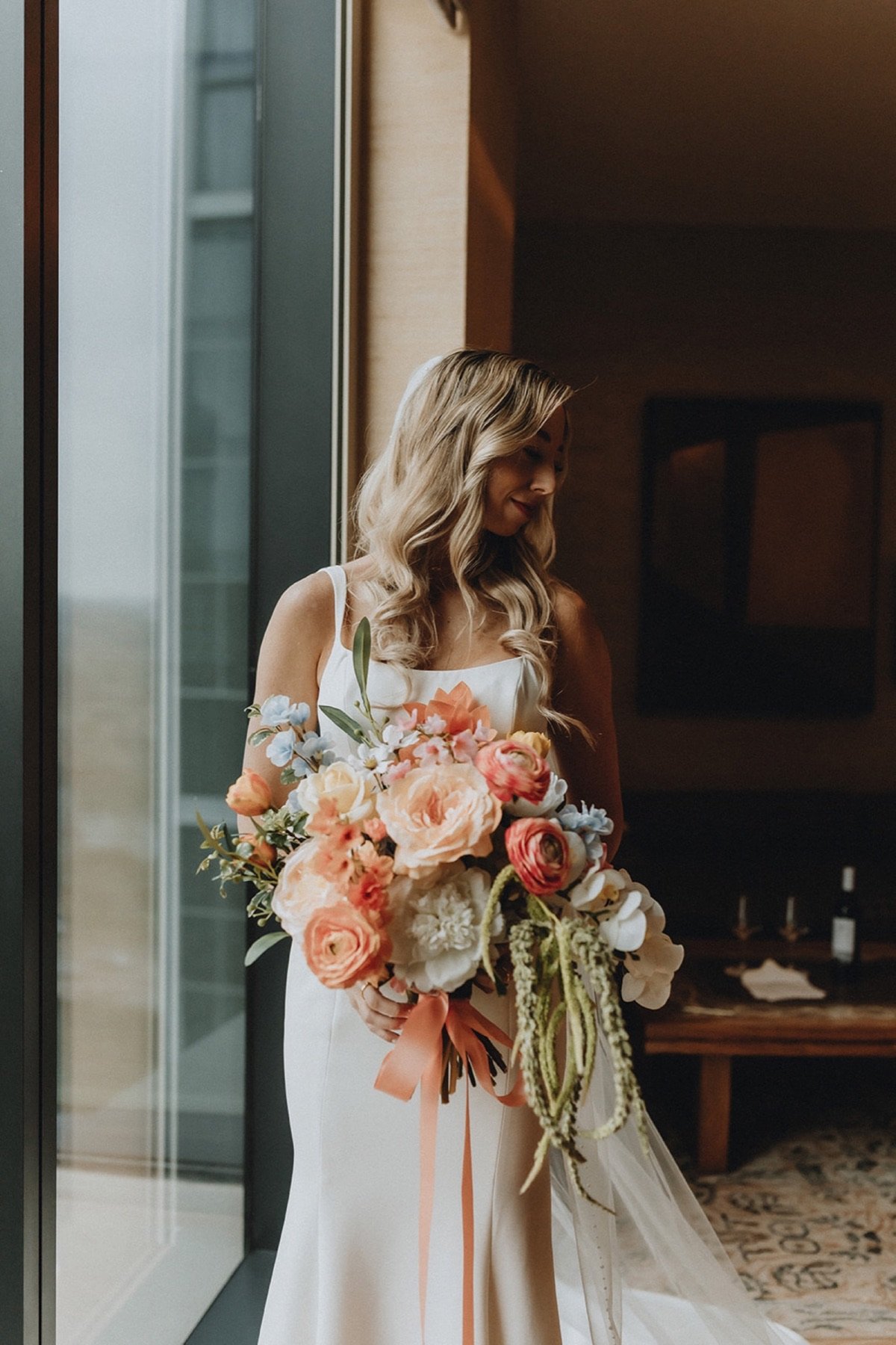 Blonde Austin bride with soft waves and a romantic floral bouquet